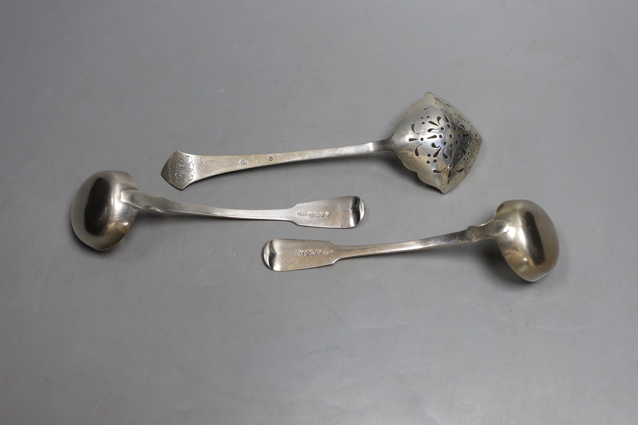 A pair of George IV Scottish silver fiddle pattern toddy ladles, James Mackay, Edinburgh 1827, and a Danish white metal sifting spoon.